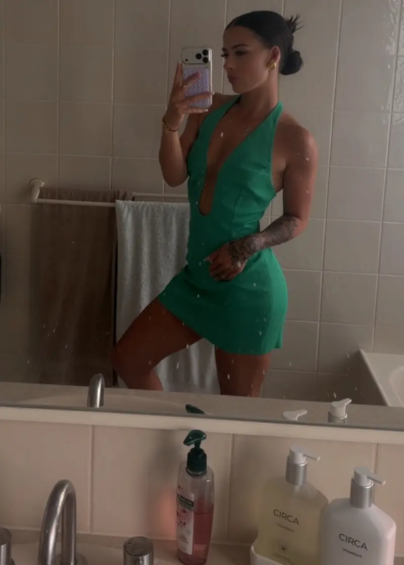 Samantha Hobley taking a mirror selfie in a green summer dress.